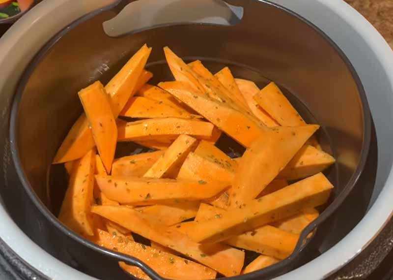 Coloque las patatas fritas de boniato de manera uniforme en la freidora de air